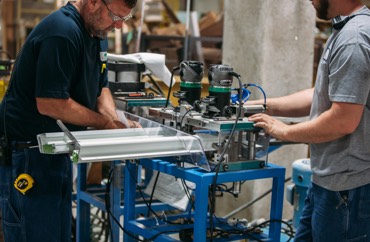 Workers with high precision routers and cutters prepping window materials